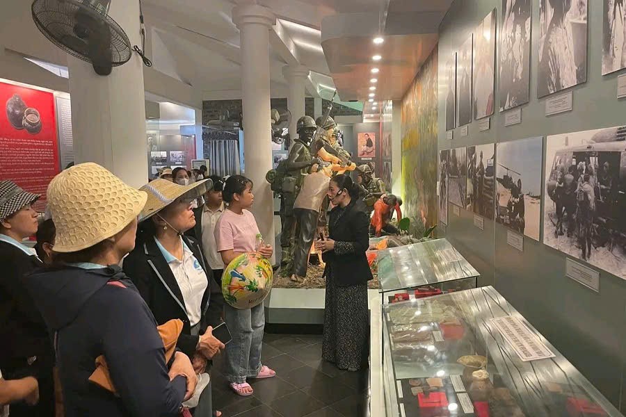 Tour guide explaining the My Lai Massacre history to visitors at Son My Memorial Museum in Quang Ngai, Vietnam