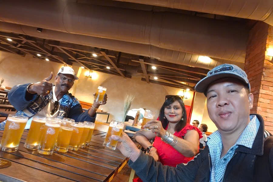 Viet Nguyen cheers beer with guests at Beer Plaza during a Ba Na Hills tour from Da Nang