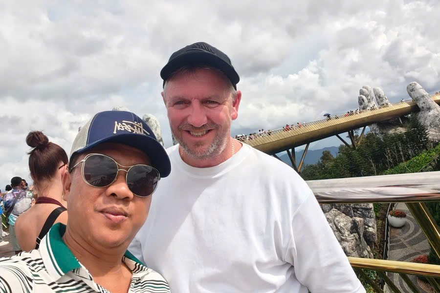 Viet Nguyen takes a selfie with guests at the Golden Bridge on a Ba Na Hills Half Day Tour from Da Nang