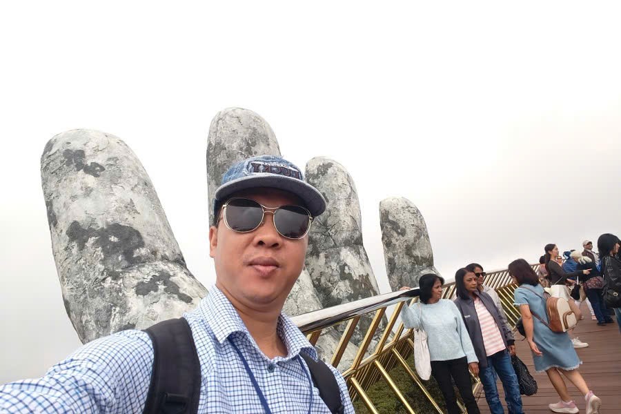 Viet Nguyen takes a selfie with guests on the Golden Bridge in Ba Na Hills