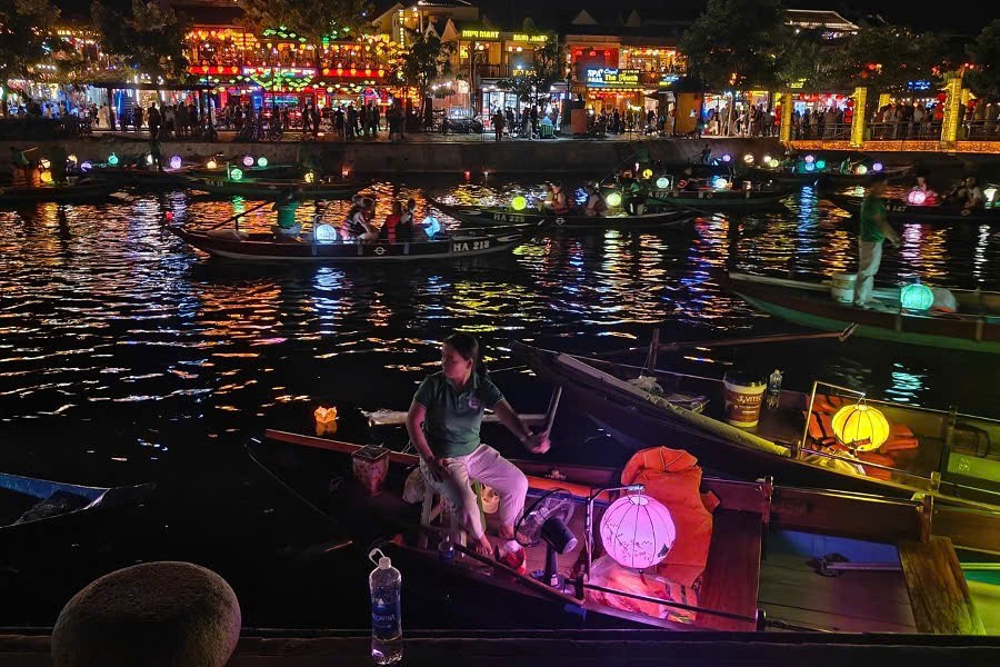 Traditional boat carrying colorful lanterns on the Hoai River in Hoi An at dusk